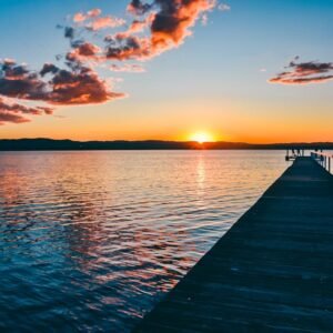 Beach Scenery - A peaceful sunset over a calm lake with a long w #16354041