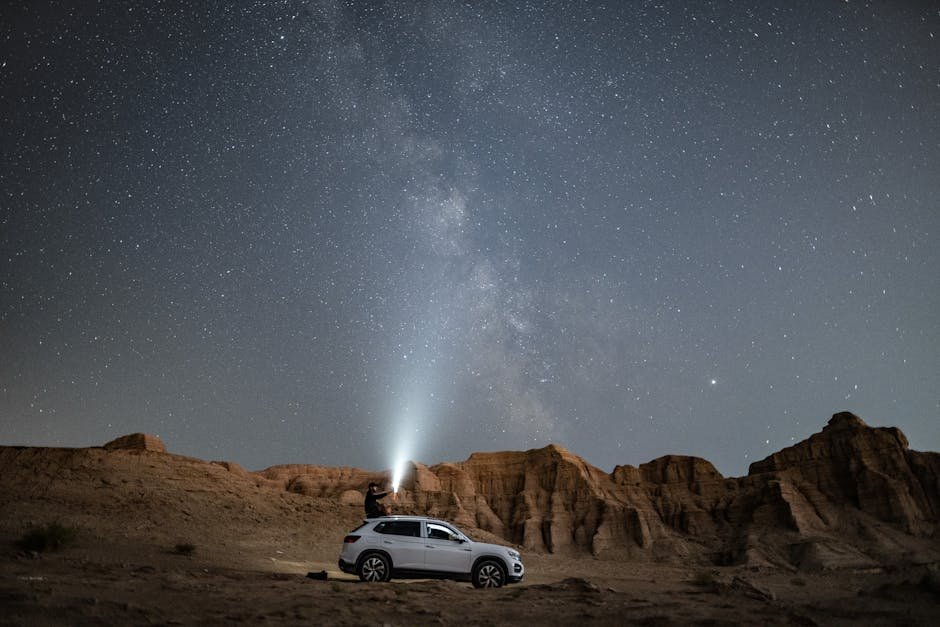 Desert Wilderness - A person stands on an SUV under a vast starry ni #3064258